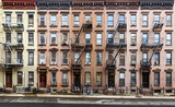 Fototapeta Nowy Jork - Block of historic apartment buildings crowded together on West 49th Street in the Hell's Kitchen neighborhood of New York City