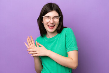 Wall Mural - Young pretty Russian woman isolated on purple background With glasses and applauding