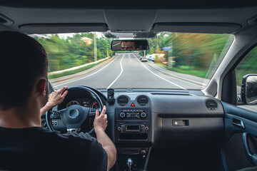 Wall Mural - Hands on the wheel when driving at high speed from inside the car.