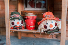 Two Scarecrow Rag Doll Faces On A Shelf