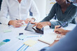 © Mumtaaz D/peopleimages.com - Hands of team with tablet and paperwork for planning company business meeting, collaboration and teamwork. Management, diversity and corporate staff writing in notebook success strategy for agency