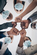 © Mumtaaz Dharsey/peopleimages.com - Fist, covid face mask or business people unity, teamwork compliance or collaboration to stop global bacteria. Zoom on worker hands or office women in support, trust or motivation against corona virus
