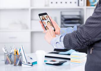 Hands of business woman using smartphone in design office