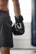 © Beaunitta V W/peopleimages.com - Boxer, fighter glove and hand close up at sports club or gym for training with equipment for fist. Athlete sportswear for protection for mma and boxing fight or workout with safety gear.