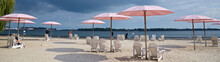 Web Banner Of Pink Beach Umbrellas And Adirondack Chairs At The Sunny Lakeshore