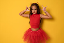 Portrait Of An Angry Little Girl In A Costume, On A Yellow Background. Halloween.