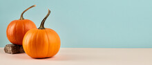 Two Orange Pumpkins On Pastel Blue Background. Autumn Concept. Seasonal Banner Design With Copy Space.