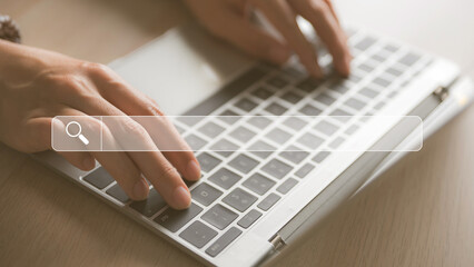 female hand typed on the keyboard to search for information in a virtual search screen box