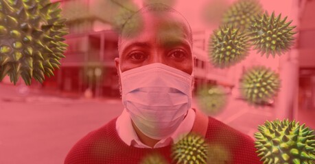 Canvas Print - Digital illustration of a man wearing coronavirus covid19 mask In the street over cells spreading