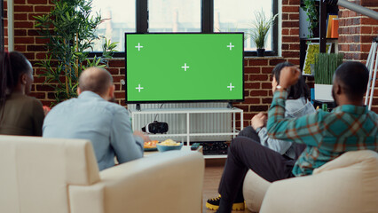 People cheering at football game match on greenscreen, using blank chroma key template to watch soccer team in championship. Sport fans looking at isolated mockup copyspace background.