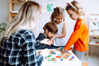 © Татьяна Волкова - Naughty boy take away and keep detail of constructor. Child not sharing toys with other kids. Educator try to resolve conflict. Children play with educational games in lesson in kindergarten
