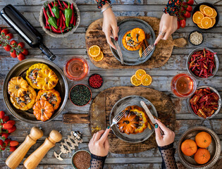 Wall Mural - Celebration dinner with family. Rose wine and stuffed pumpkin with rice and vegetables. Vegan food with table top view. 