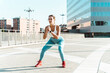 © Westend61 - Young woman exercising with resistance band on footpath