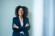 © Westend61 - Cheerful businesswoman with arms crossed in front of wall