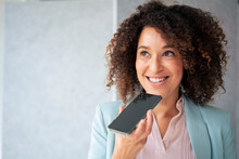 Smiling Businesswoman Sending Voicemail Through Smart Phone