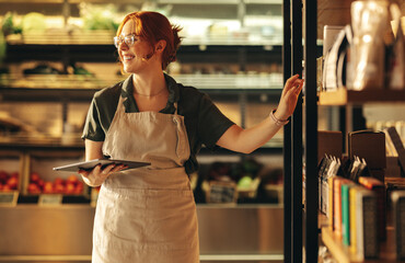 Successful shop owner smiling happily in her grocery store