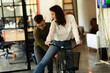 © JustLife - Colleagues in office. Businesswoman and businessman with bicycle. Two friends having fun together