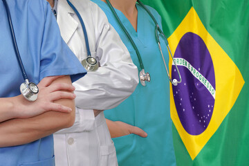 Wall Mural - Three Doctors with stethoscope in standing on Brazil flag background. Close-up medical team. Group of doctors and nurses. Innovative technologies in science and medicine, medical development in Brazil