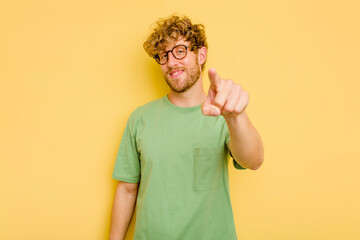 Young caucasian man isolated on yellow background cheerful smiles pointing to front.