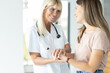 © Panorama - Female blonde senior doctor holding patient hands and having a positive talk