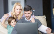 © Panorama - Three member family havign their time in living roomFather is working remotely