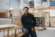 © Jacob Lund - Happy logistics worker smiling at the camera in a warehouse