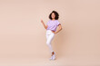 Leinwandbild Motiv Full length photo of girl striped t-shirt white trousers sneakers hand on waist directing empty space isolated on beige color background