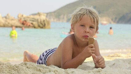 Poster - Happy child, boy eating ice cream  on the beach, enjoying summer, playing. Halkidiki, Greece