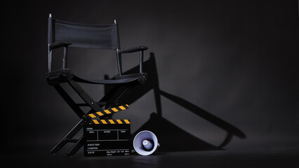 Black director chair and Clapperboard or movie slate with and megaphone on black background.