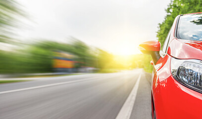 Wall Mural - Red car on the road at sunset.