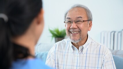 A young female doctor inquires about personal information of a contented senior at home. Medical care for the elderly, elderly illness, and nursing homes, home care.