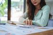 © Jirapong - female employee using a calculator to calculate financial documents