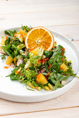 Wall Mural - Juicy salad with arugula , orange and avocado. On a light background.