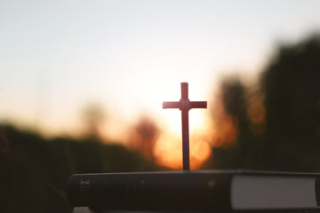 Bright sunlight, bible and holy jesus christ cross silhouette
