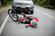 © VStudio - An Asian mountain biker was hit by a car on the road. A mountain biker was injured in a collision with a car on the road. Concept reduces accidents from using cars on the road. Selective focus.