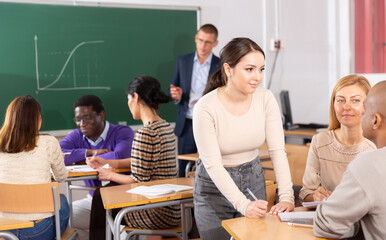 Wall Mural - Adult people working in small groups during professional training course, discussing task set by teacher