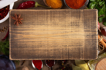 Canvas Print - Variety of spices and herbs wood cutting board at table background. Cooking concept and ingredients