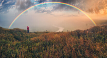 Woman Looking At Rainbow. rainbow over the autumn river. nature of Ukraine