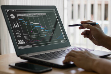 Corporate strategy for finance, operations, sales, marketing. Analyst working with computer in Business Analytics and Data Management System to make report with KPI and metrics connected to database.