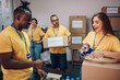 © Zamrznuti tonovi - Group of multiracial volunteers working in community charity donation center