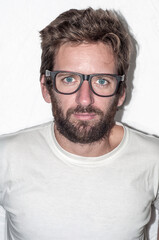 Caucasian blond-haired man with glasses, wearing a white shirt looking at the camera.