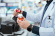 © 2B - A male pharmacist checks drug stocks in a community pharmacy.