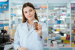 © 2B - A young pharmacist handed a box of pills to the box with a smile in the pharmacy.