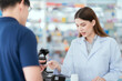 © 2B - A young pharmacist advises patients on the purchase and use of medicines. Counter area for trading and services
