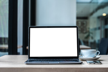 Wall Mural - Mockup of laptop computer with empty screen with coffee cup and smartphone on table of the coffee shop background,White screen