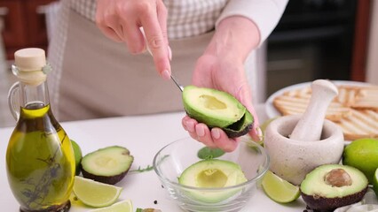 Canvas Print - Woman peeling a half of avocado fruit with a spoon