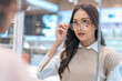 Attractive asia Young adult female woman casual cloth spending weekend vacation enjoy choosing glasses in optical store shop she is pick the favourite one for herself