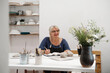 © ninelutsk - Banner Woman potter planning work at workshop, writing in notebook in light studio her creations. Clay pieces on the table. Small creative business. Copy space