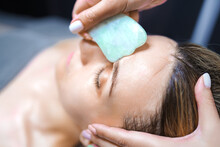 Woman Having An Gua Sha Facial Massage With Natural Jade Stone Massager In The Salon