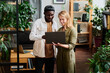 © pressmaster - Two young intercultural employees in casualwear looking at screen of laptop held by blond businesswoman during discussion